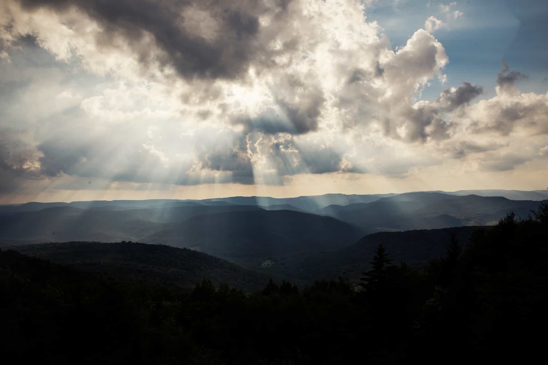 sun breaking through the clouds over the mountains