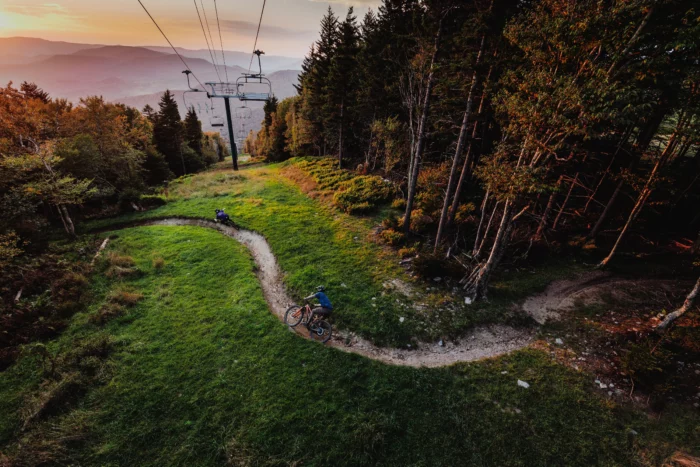 Two people mountain biking on a winding trail