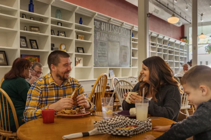 Family eating and talking together at restaurant table.
