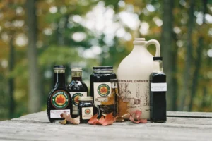 Frostmore Farm maple syrup products displayed on a wooden table outdoors