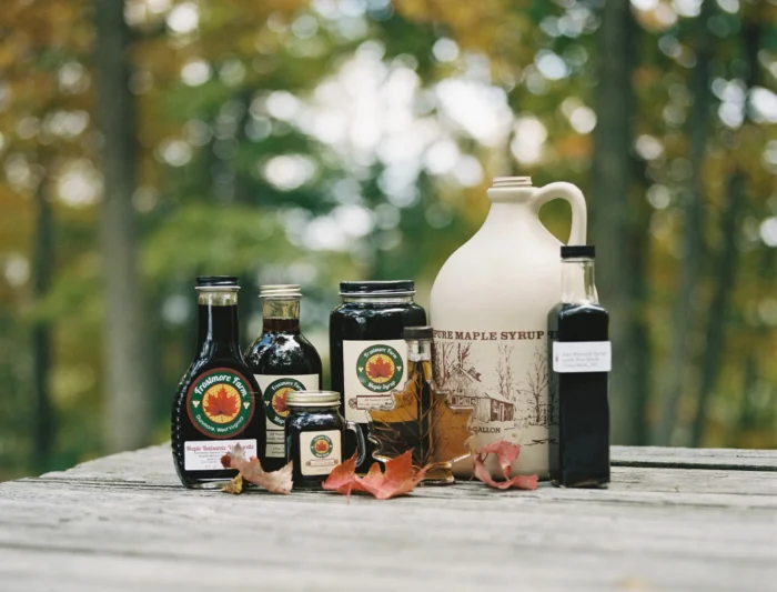 Frostmore Farm maple syrup products displayed on a wooden table outdoors