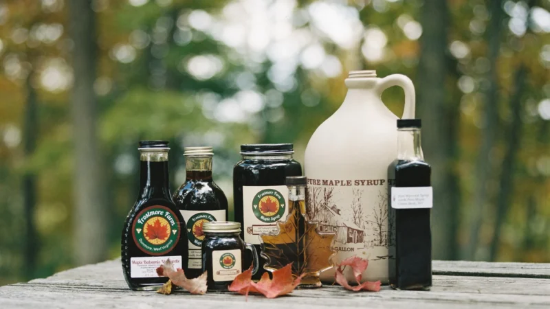 Frostmore Farm maple syrup products displayed on a wooden table outdoors