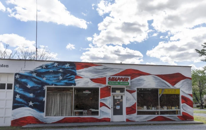 A large American flag mural covering the exterior wall of a Snapper Mowers and Tillers shop.