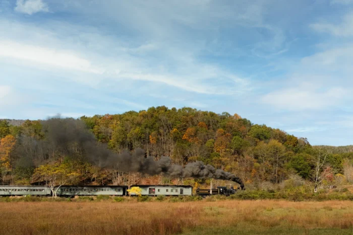 A steam-driven train travels through Pocahontas County, surrounded by fall foliage.